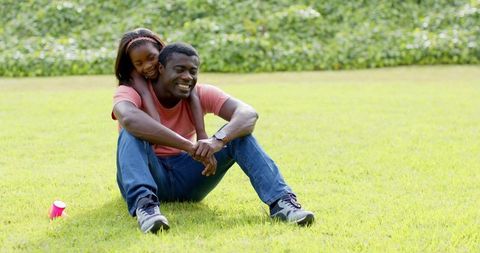 Joyful Father and Daughter Bonding Outdoors on Green Lawn