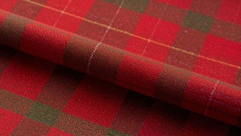 Folded red green tartan wool fabric showing plaid texture and brushed nap closeup