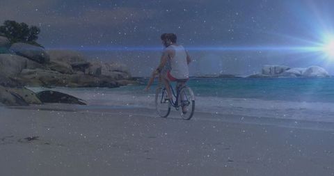 Romantic Couple Cycling on Beach at Twilight