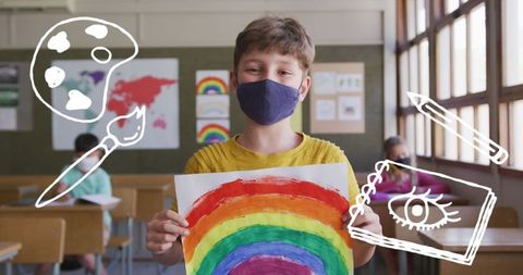 Creative Boy Holding Rainbow Art in Classroom with Mask