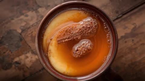 Overhead Close-up Lemon Cinnamon Tea Cooling in Rustic Mug on Wood Table with Cinnamon Stick