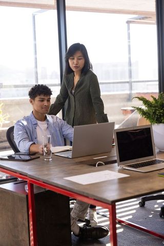 Creative team collaborating in modern workspace near window