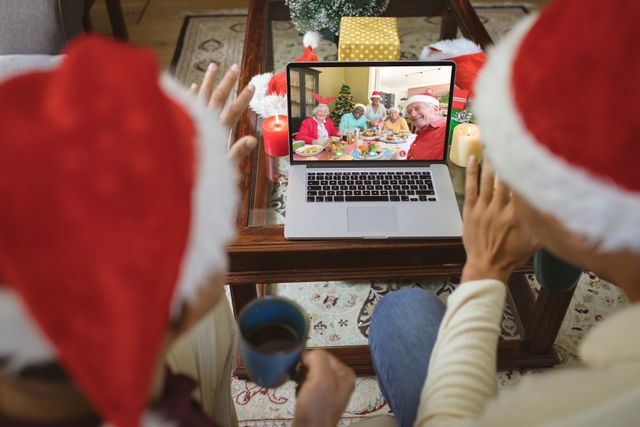 Diverse couple with santa hats having video call with happy diverse friends. Christmas, celebration and digital composite image.