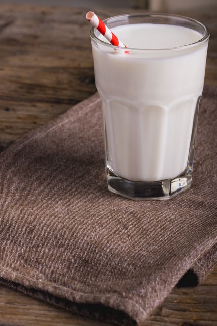 Glass of Milk with Red Striped Straw on Brown Napkin - Download Free Stock Photos Pikwizard.com