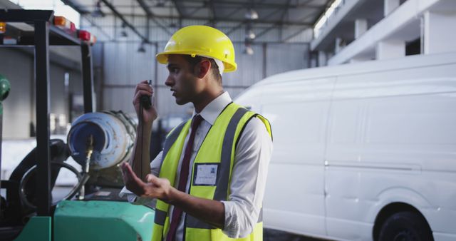 Warehouse Manager Communicating via Two-Way Radio for Logistics Coordination - Download Free Stock Images Pikwizard.com