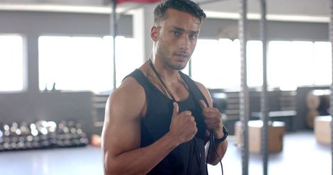 Focused Trainer with Jump Rope in Modern Gym