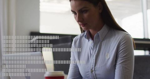 Focused Businesswoman in Office with Laptop and Coffee