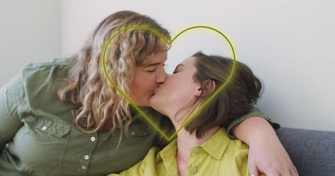 Loving Lesbian Couple Kissing Inside Neon Heart Symbol