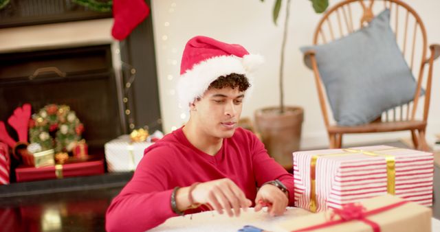 Man Wrapping Christmas Presents in Festive Living Room - Download Free Stock Images Pikwizard.com