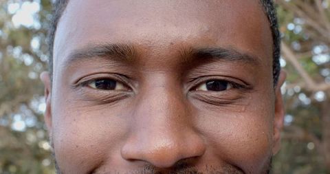 Closeup portrait african american man smiling, showing natural skin texture, beard and warm gaze