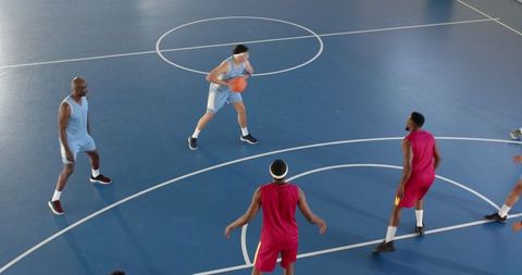 Basketball Game Action on Indoor Blue Court with Five Players