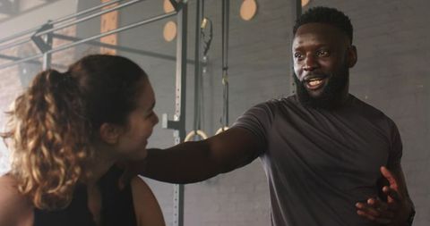 Personal trainer guiding client in modern gym environment