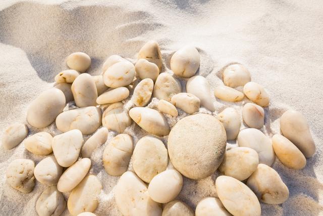 Close-up of white pebbles on sand surface at the beach