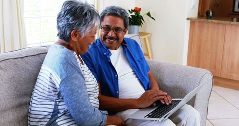 Middle-aged Couple Enjoying Time Together with Laptop