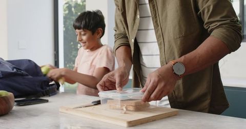 Father and son preparing lunch together in modern kitchen