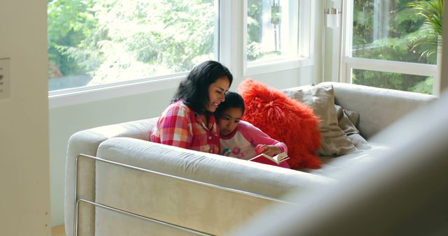 Mother Reading Book with Daughter on Cozy Sofa at Home - Download Free Stock Images Pikwizard.com