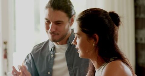 Excited couple planning wedding with laptops