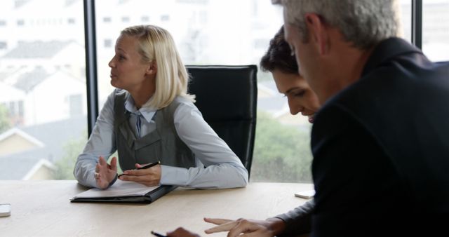 Business professionals discussing at conference table in bright office - Download Free Stock Images Pikwizard.com