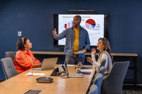 Diverse team presenting quarterly results and strategy in modern boardroom meeting