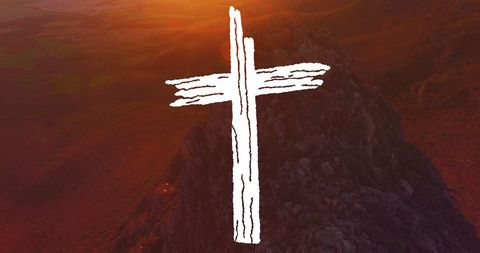 Abstract white crucifix over mountain landscape at sunrise
