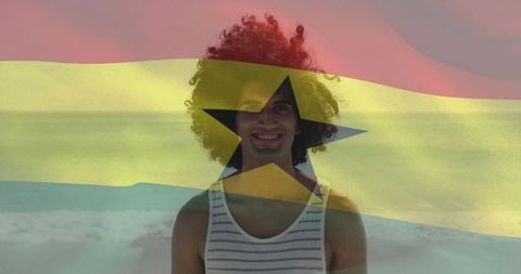 Smiling man on beach with ghana flag overlay celebrating national pride and coastal travel