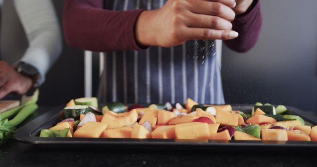 Hands Sprinkling Salt Over Freshly Cut Vegetables on Cooking Tray - Download Free Stock Images Pikwizard.com