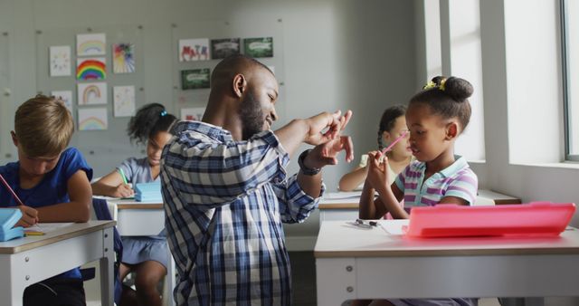 Image of happy african american teacher learning african american girl how to count in classroom. primary school education and teaching profession.