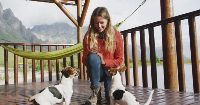 Young woman training two Jack Russell Terriers on wooden deck in nature - Download Free Stock Images Pikwizard.com