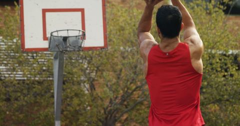 Athlete Shooting Basketball Outdoors in Mid-Action