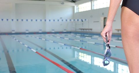 Female Swimmer by Indoor Pool in Ready Position