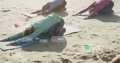 Senior Women Using Social Media While Yoga Exercising on Beach