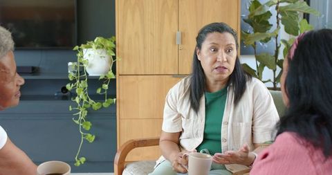 African american women sharing coffee and conversation in cozy living room