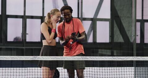 Diverse athletes discussing strategy on padel court