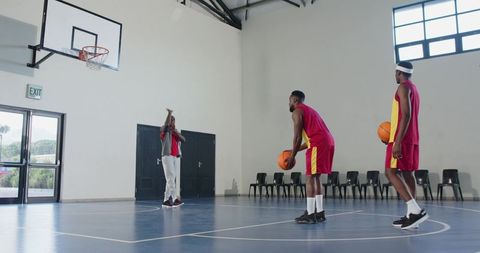 Coach Training Players in Indoor Basketball Court
