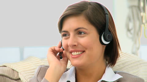 Professional Businesswoman Smiling While Using Headset for Communication