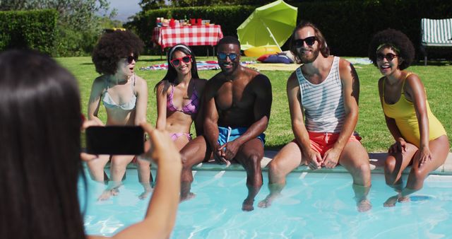 Group of diverse friends posing for a picture while sitting by the pool. youth friendship and pool party concept
