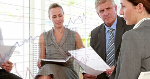 Business team analyzing financial data charts in office