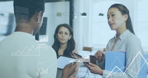 Diverse women in office collaborating with digital technology