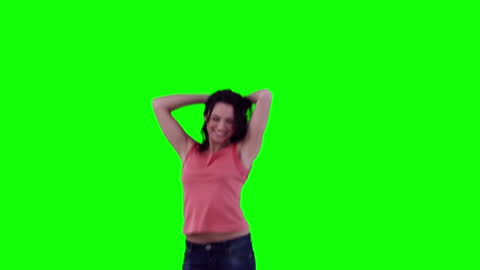 Joyful Woman Dancing in Front of Bright Green Background