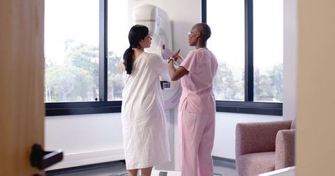 Radiologic Technologist Guiding Patient During Mammogram Appointment in Clinic