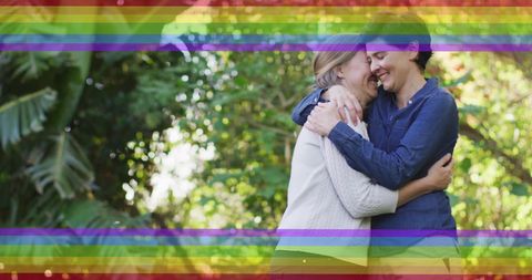 Happy LGBTQ Couple Embracing in Green Garden with Rainbow Overlay