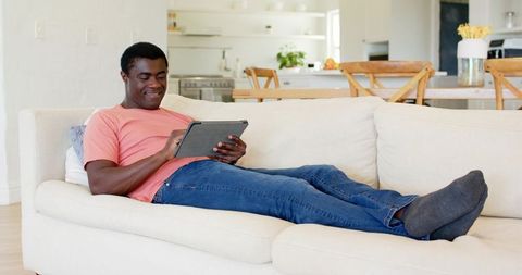 Man Relaxing on Sofa with Tablet in Modern Home Interior