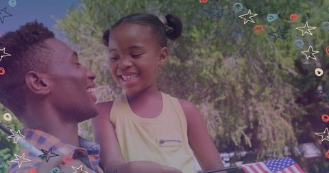 Father and Daughter Celebrating with American Flags Outdoors