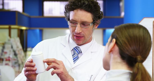 Pharmacist assisting the bottle of drug to customer in pharmacy 4k - Download Free Stock Photos Pikwizard.com