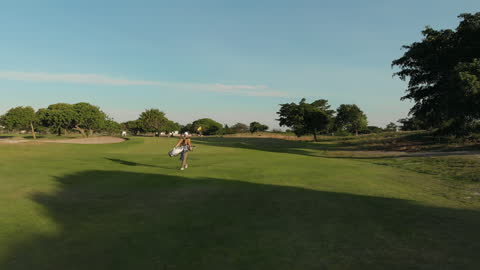 Golfer Walking Toward Final Hole on a Sunny Course
