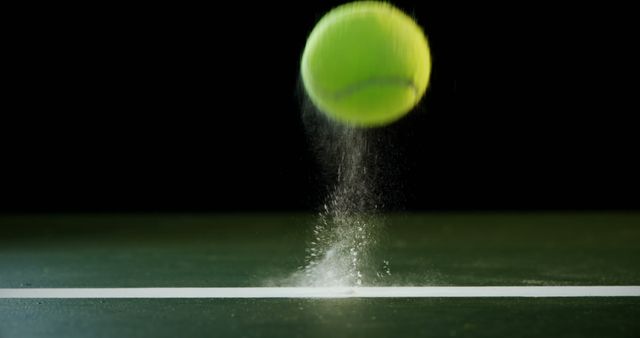 Tennis ball hitting and bouncing on court with visible dust and motion blur. Great for sports-related content, articles showcasing athleticism, tennis clubs, or promotional materials for tennis equipment and events.