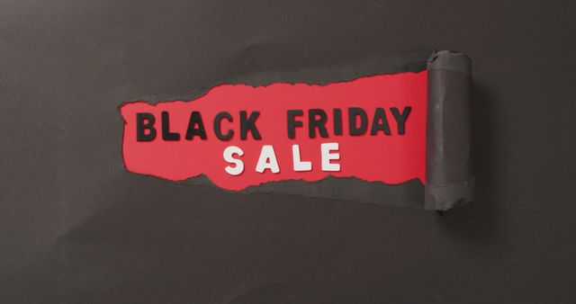 Ripped black paper with black friday sale text in black and white on red background. Black friday, shopping, sale and retail concept digitally generated image.