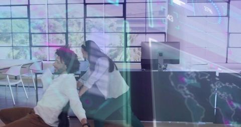 Woman pushing man on rolling chair in futuristic open-plan office with holographic hud