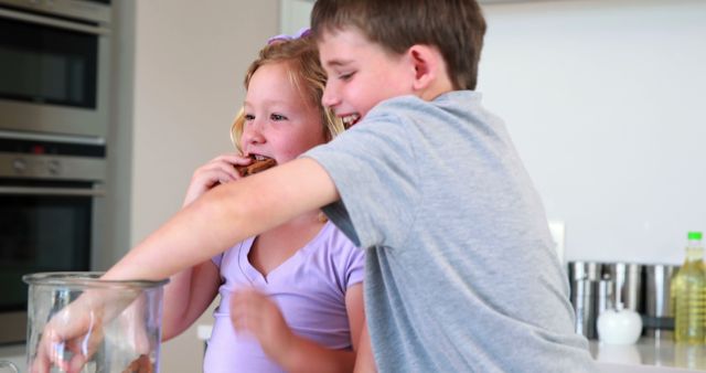 Happy Siblings Enjoying Freshly Baked Cookies in Kitchen - Download Free Stock Images Pikwizard.com