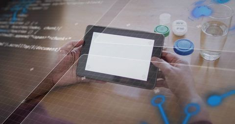 Hands holding tablet with blank screen and digital grid overlay for app prototype healthcare